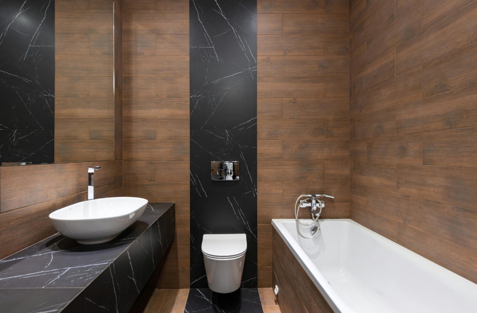 Bathroom finished in wood-effect porcelain with a black marble feature panel